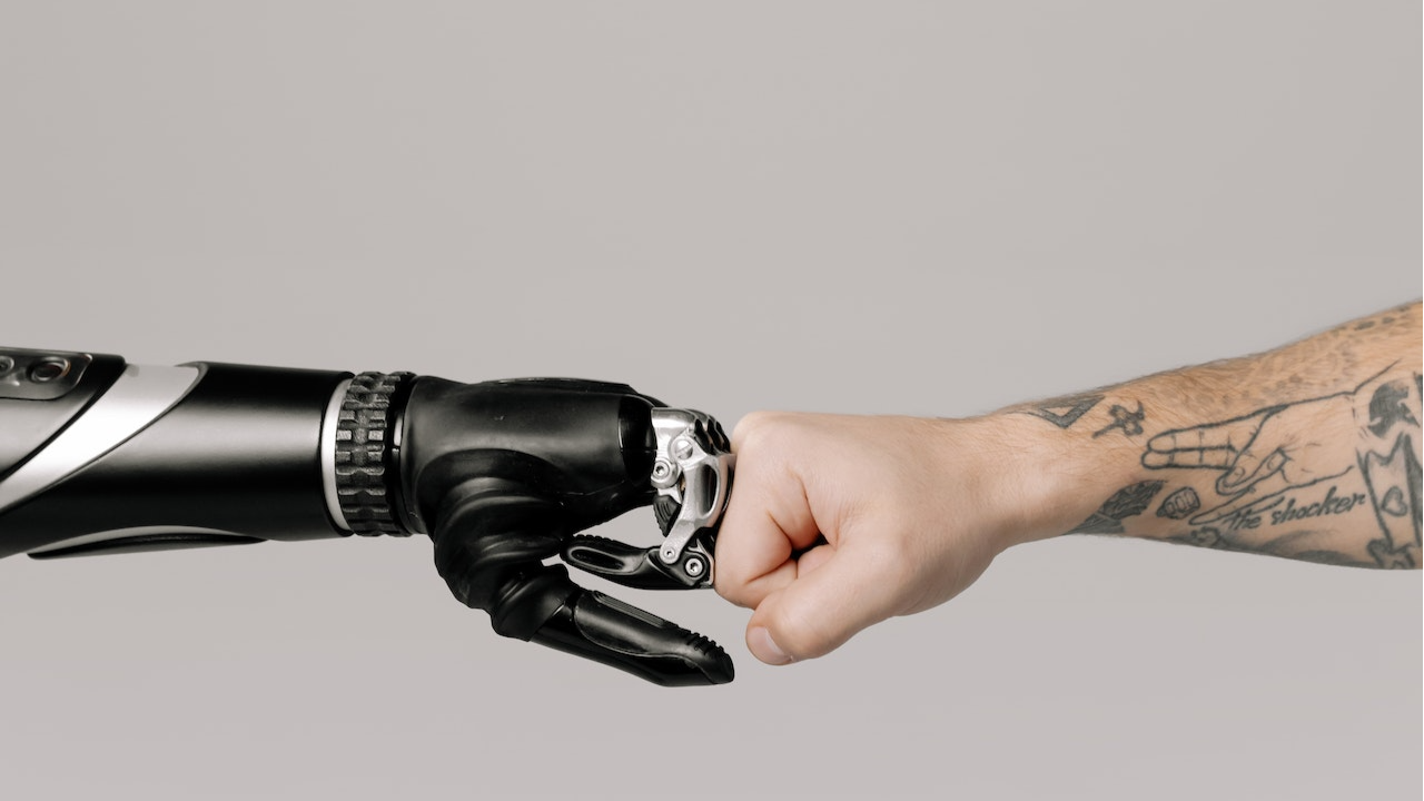 Imagen de IA en reclutamiento, brazo artificial y brazo humano
